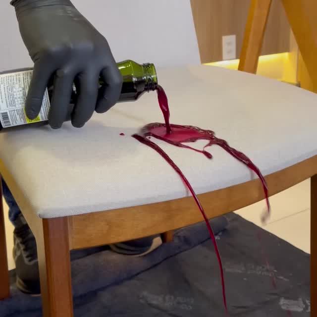 Technicien Docteur Sofa, avec masque, lunettes, gants et protections aux pieds, nettoyant les coussins d'un canapé clair.
